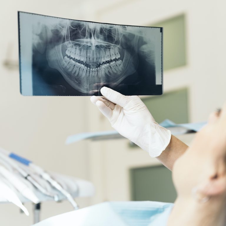 Doctor talking with her patient and teaching a radiograph. Medical Concept.