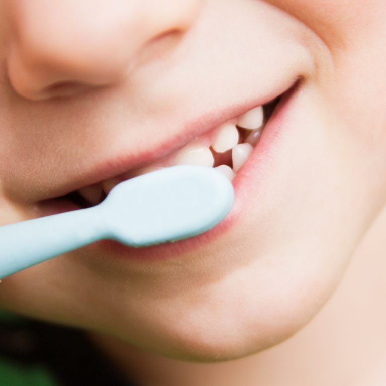 child's teeth with a toothbrush