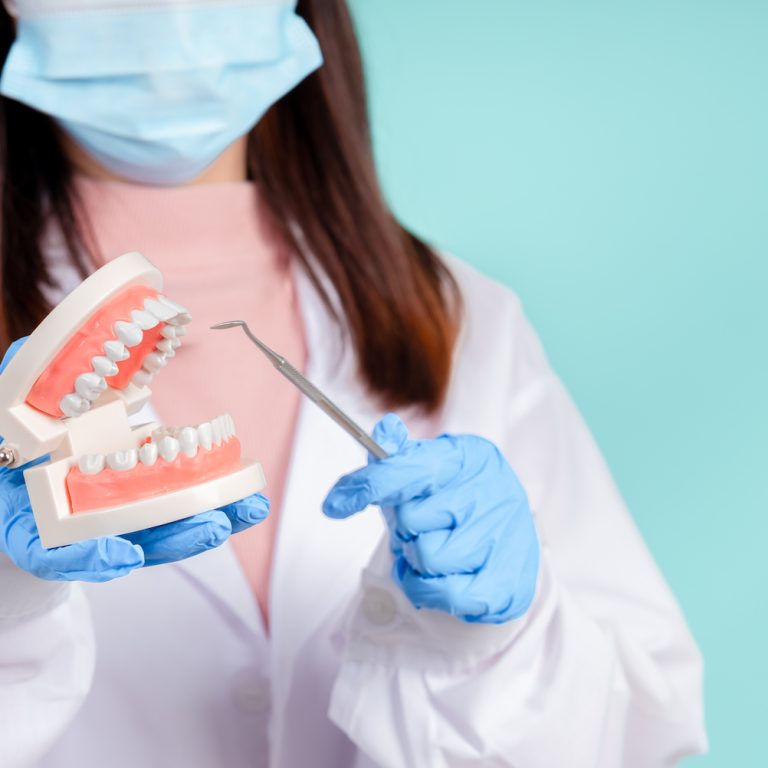 Asian dentists are teaching them how to care for oral and dental care, including after correct orthodontic treatment on blue background isolated studio shot.